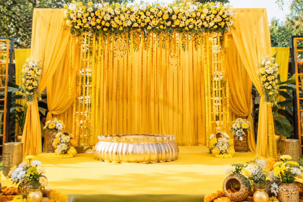 Luxury haldi ceremony decoration with yellow drapes, fresh marigold flowers and elegant floral backdrop in Delhi NCR.