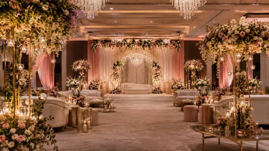 Event management company in Gurgaon offering luxury event decoration with floral stage backdrop, elegant seating, chandeliers and warm lighting.